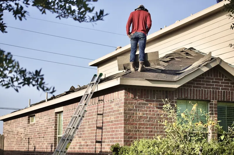 Professional roofer working on a residential roof in Otis Orchards